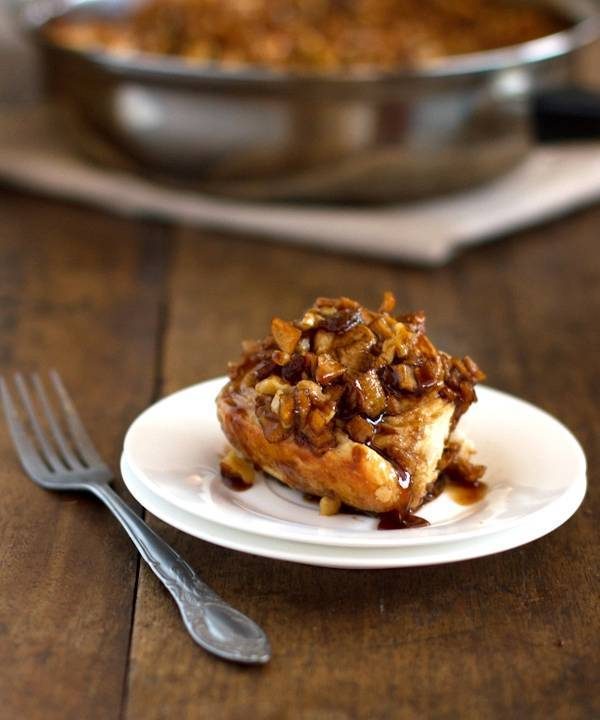 Caramel roll on a white plate with a fork.